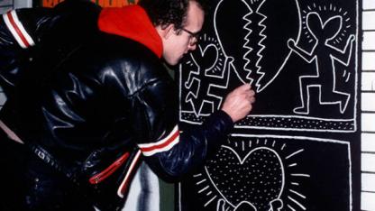Keith Haring zeichnet ein Graffito an eine Wand. Standbild aus dem Film &quot;The Universe of Keith Haring&quot;.